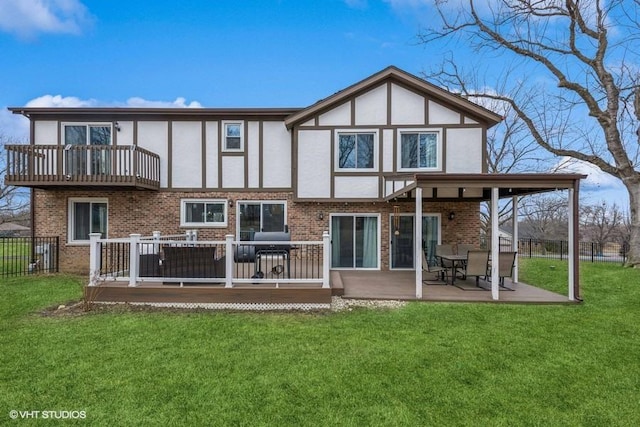 rear view of property featuring a wooden deck, a balcony, and a yard