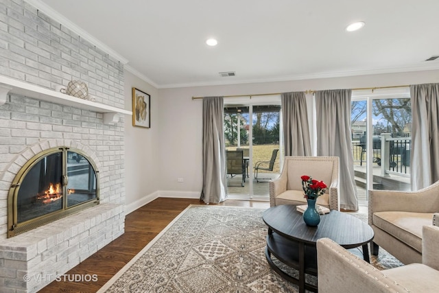 living room with ornamental molding, dark hardwood / wood-style flooring, a brick fireplace, and plenty of natural light