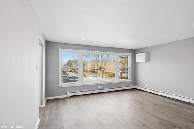 spare room with light wood-type flooring and a baseboard radiator