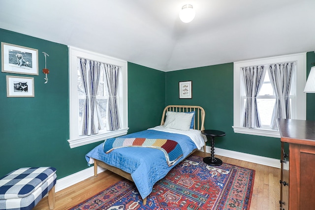 bedroom with hardwood / wood-style flooring and lofted ceiling