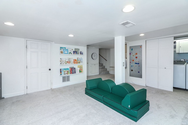 living room with washer / clothes dryer and light carpet