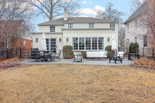 back of house with outdoor lounge area, a patio, and a lawn