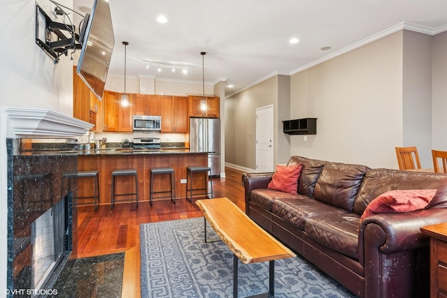 living room featuring crown molding, a fireplace, and dark hardwood / wood-style floors