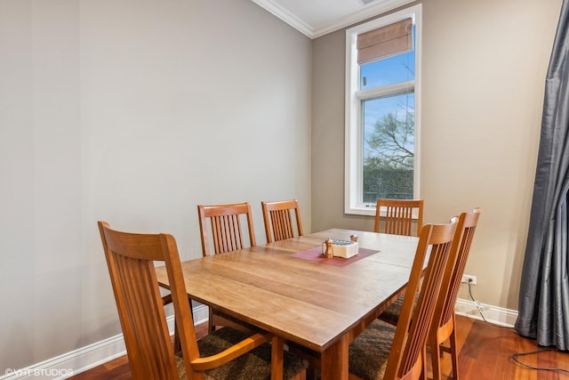 dining space with dark hardwood / wood-style flooring and ornamental molding