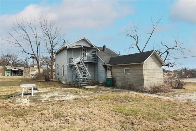 rear view of property featuring a yard and a patio area