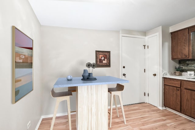 kitchen with light hardwood / wood-style flooring and a kitchen breakfast bar