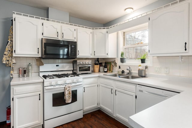 kitchen with tasteful backsplash, white appliances, sink, and white cabinets