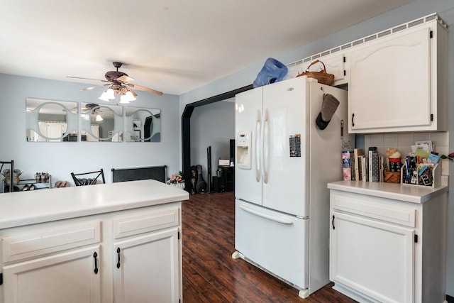 kitchen with dark hardwood / wood-style floors, white cabinetry, decorative backsplash, white refrigerator with ice dispenser, and ceiling fan