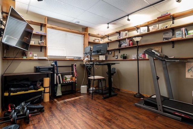 interior space featuring rail lighting, dark wood-type flooring, and a drop ceiling