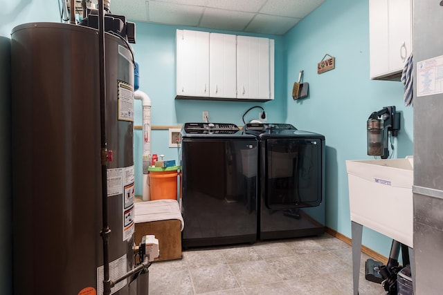 laundry room featuring cabinets, washing machine and clothes dryer, and gas water heater