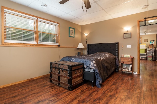 bedroom with dark hardwood / wood-style flooring, a paneled ceiling, and ceiling fan