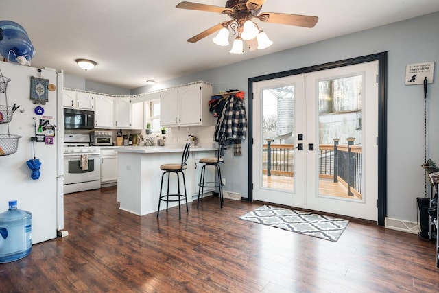 kitchen featuring white cabinetry, a kitchen bar, kitchen peninsula, white appliances, and french doors