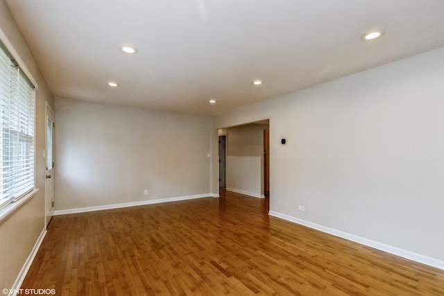 spare room featuring baseboards, wood finished floors, and recessed lighting