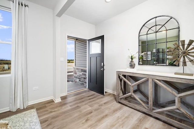 entryway with baseboards and wood finished floors