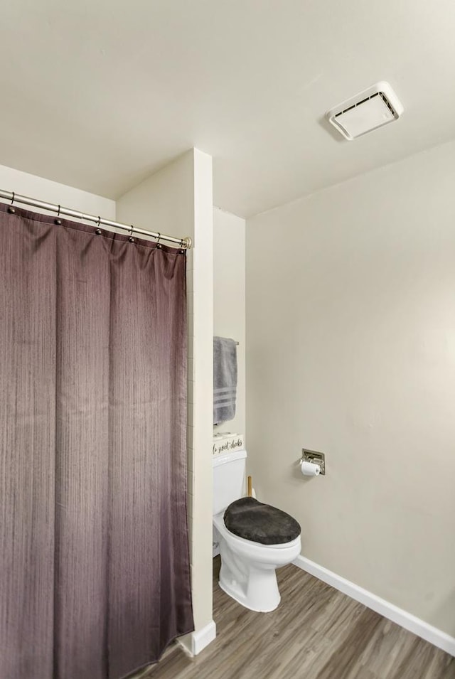 bathroom with wood-type flooring and toilet