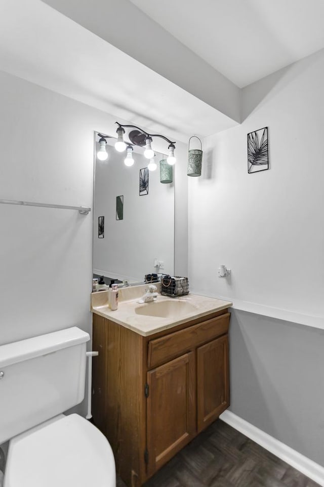 bathroom featuring vanity, parquet floors, and toilet