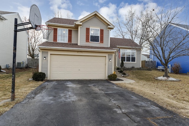 view of front of home with a garage and central air condition unit