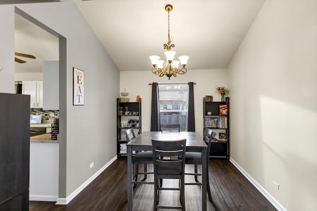 dining space with dark hardwood / wood-style flooring and a chandelier