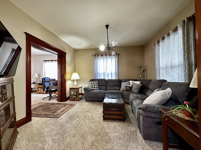 carpeted living room with a healthy amount of sunlight and a chandelier