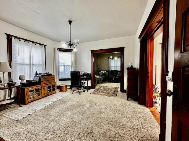 carpeted office space featuring a notable chandelier