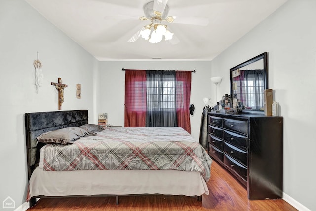 bedroom with multiple windows, wood-type flooring, and ceiling fan