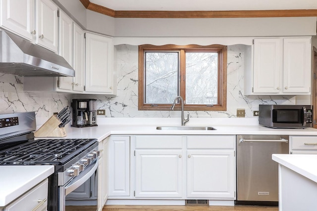 kitchen featuring stainless steel appliances, white cabinetry, sink, and decorative backsplash