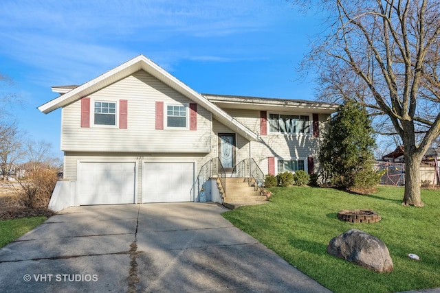 bi-level home featuring driveway, a garage, a fire pit, fence, and a front lawn