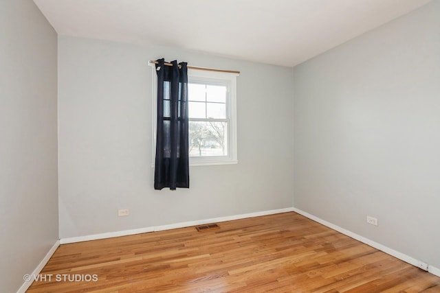 unfurnished room with visible vents, baseboards, and wood finished floors