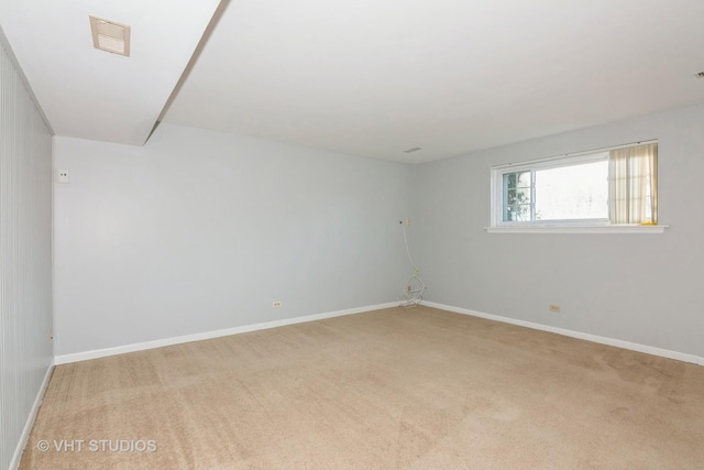 spare room with light carpet, visible vents, and baseboards