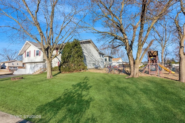 view of yard featuring a garage, a residential view, and a playground