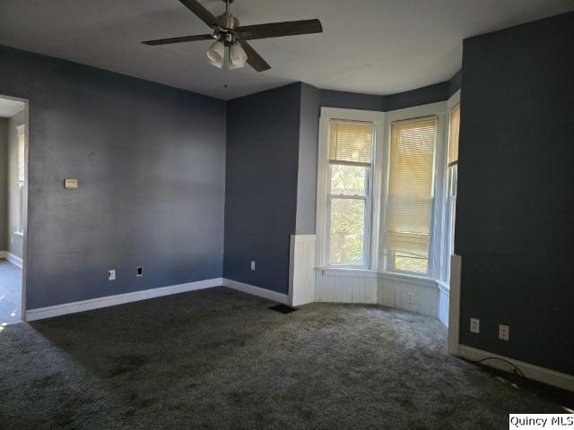 carpeted empty room featuring ceiling fan