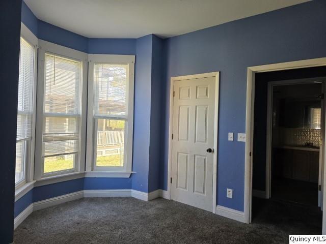 unfurnished bedroom featuring dark colored carpet