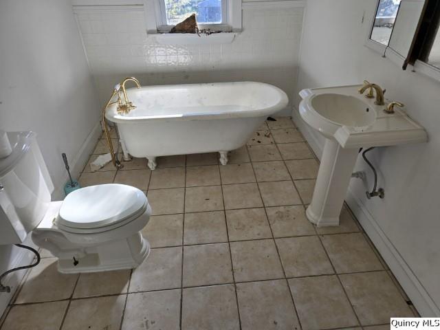 bathroom featuring tile patterned flooring, a bathtub, and toilet