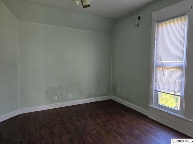 unfurnished room featuring dark hardwood / wood-style flooring and vaulted ceiling