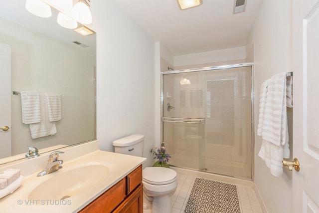 bathroom with tile patterned flooring, vanity, an enclosed shower, and toilet