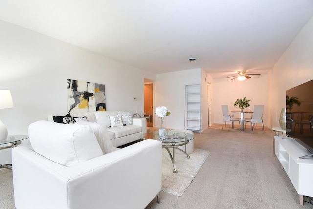 carpeted living room with ceiling fan