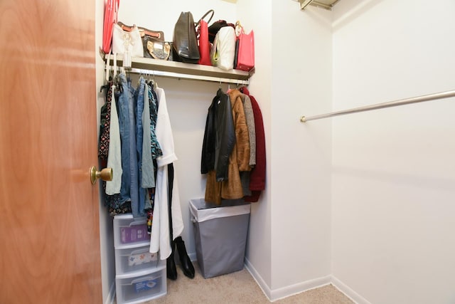 walk in closet featuring light colored carpet