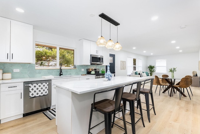 kitchen featuring white cabinetry, pendant lighting, stainless steel appliances, and a center island