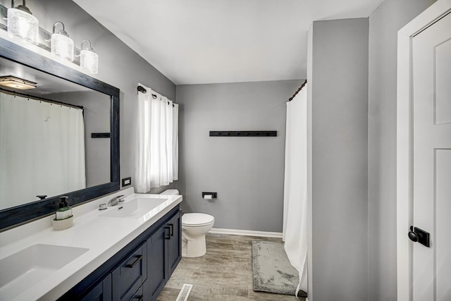 bathroom featuring wood-type flooring, vanity, and toilet