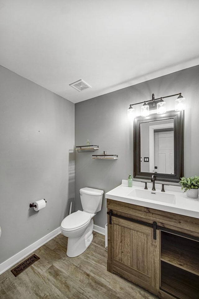 bathroom with vanity, hardwood / wood-style flooring, and toilet