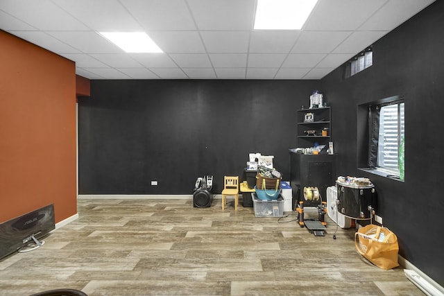 basement featuring hardwood / wood-style floors and a paneled ceiling