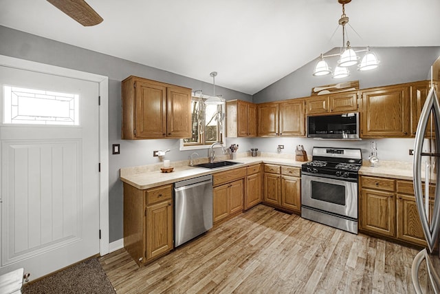 kitchen with hanging light fixtures, light wood-type flooring, sink, and appliances with stainless steel finishes