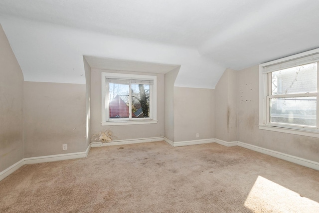 bonus room featuring lofted ceiling and light carpet