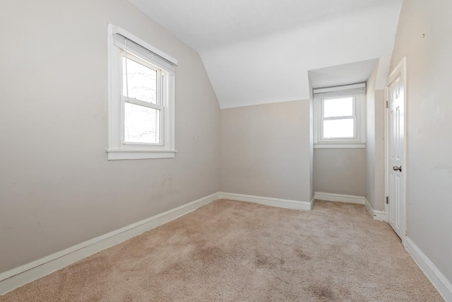 additional living space featuring lofted ceiling and light colored carpet