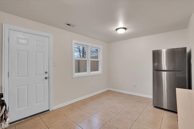 kitchen featuring light tile patterned floors and stainless steel refrigerator