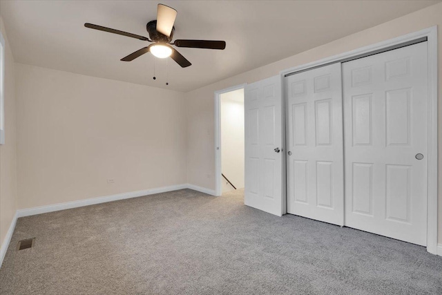 unfurnished bedroom with ceiling fan, light colored carpet, and a closet