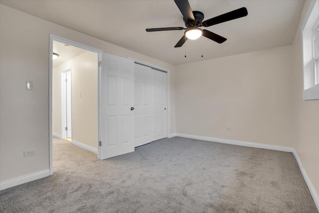 unfurnished bedroom featuring ceiling fan, a closet, and light carpet