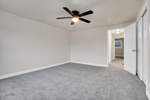 carpeted spare room with ceiling fan