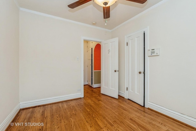 unfurnished room with light wood-type flooring, baseboards, and crown molding