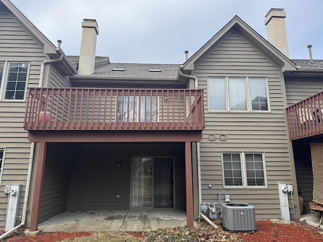 rear view of house with central AC, a patio area, and a balcony